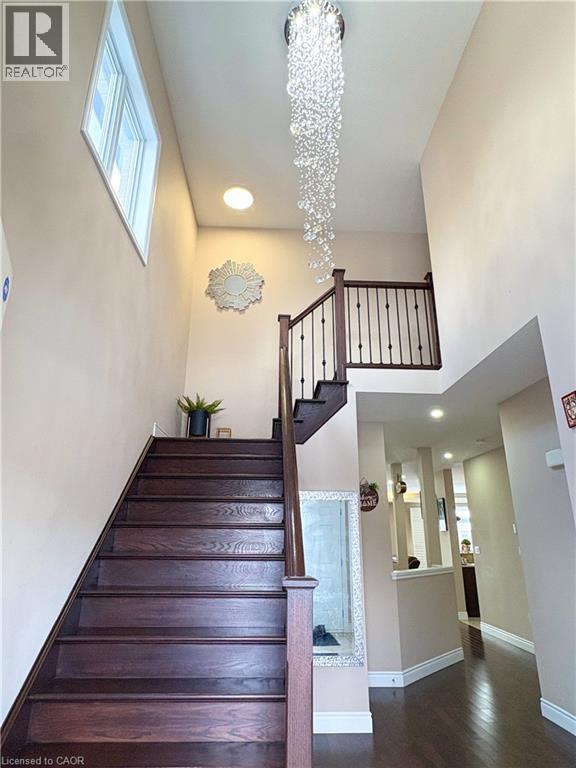 Staircase featuring a towering ceiling, a chandelier, and hardwood / wood-style flooring - 34 Watervale Drive Unit# Upper, Kitchener, ON - Indoor Photo Showing Other Room