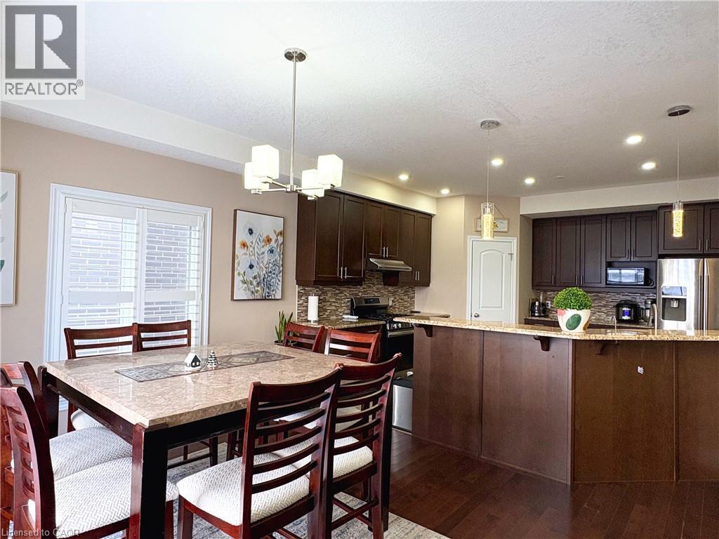 Kitchen with tasteful backsplash, hanging light fixtures, dark brown cabinets, and stainless steel appliances - 34 Watervale Drive Unit# Upper, Kitchener, ON - Indoor Photo Showing Dining Room