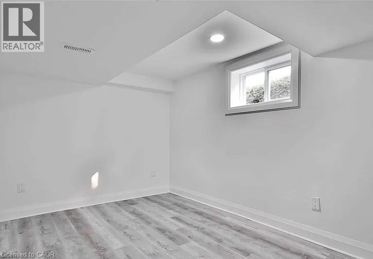 Bedroom 2 with light wood-style flooring and baseboards - 549 Waterloo Street, Hamilton, ON - Indoor Photo Showing Other Room