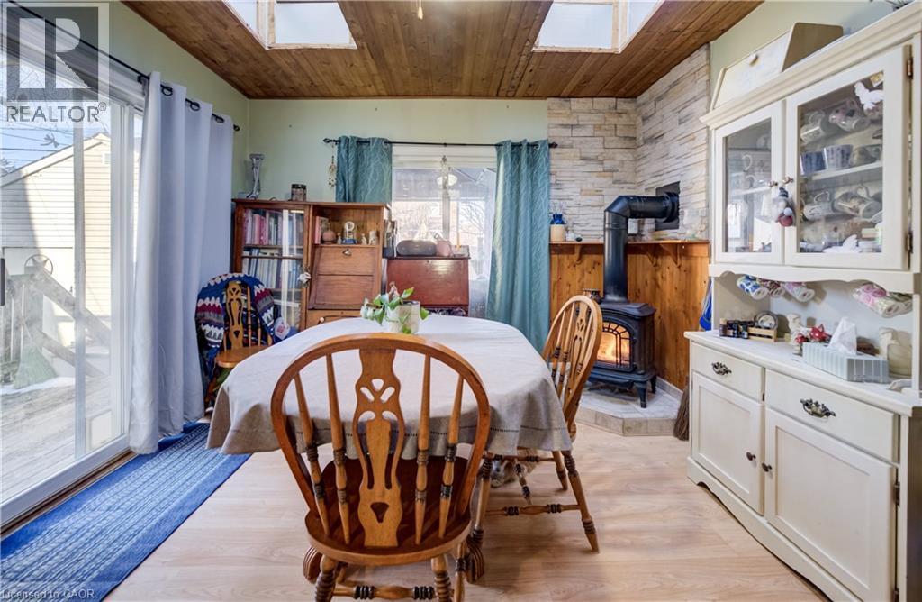 dining area with gas fireplace, sliding doors to backyard - 12 Leinster Avenue S, Hamilton, ON - Indoor Photo Showing Dining Room