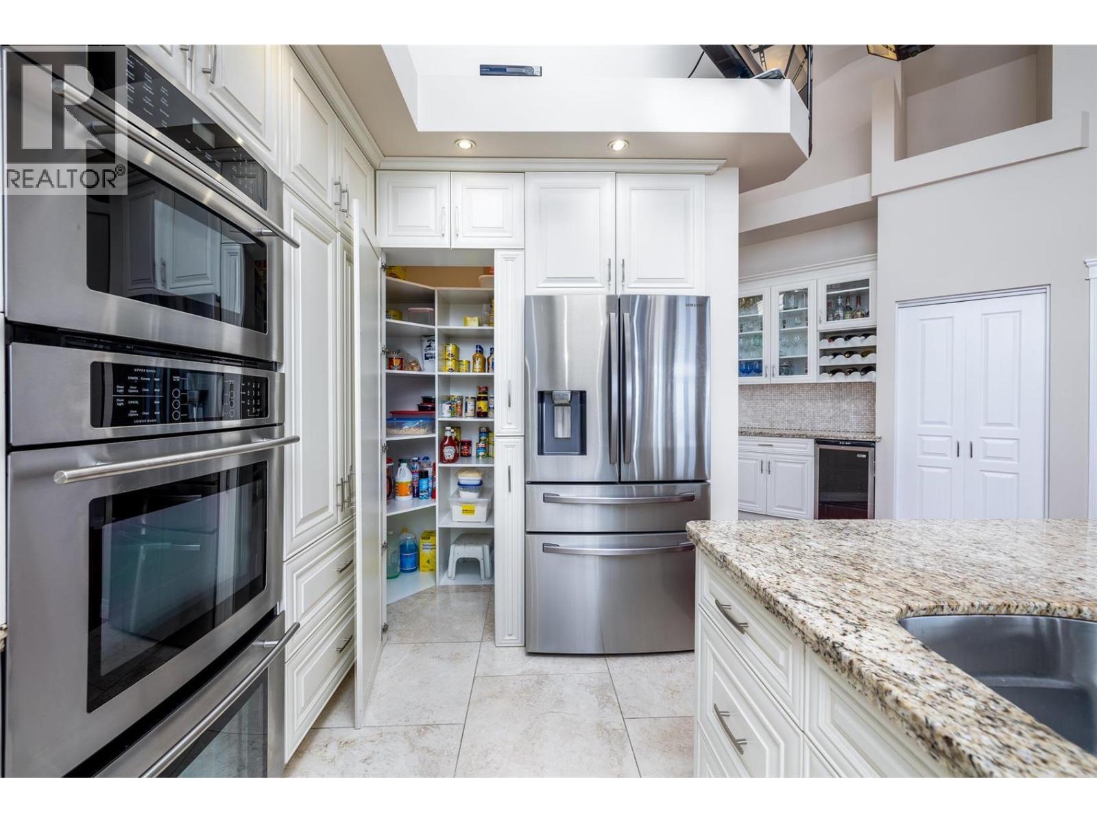 Large pantry hiding as part of the cabinet - 375 Trumpeter Court, Kelowna, BC - Indoor Photo Showing Kitchen With Double Sink With Upgraded Kitchen