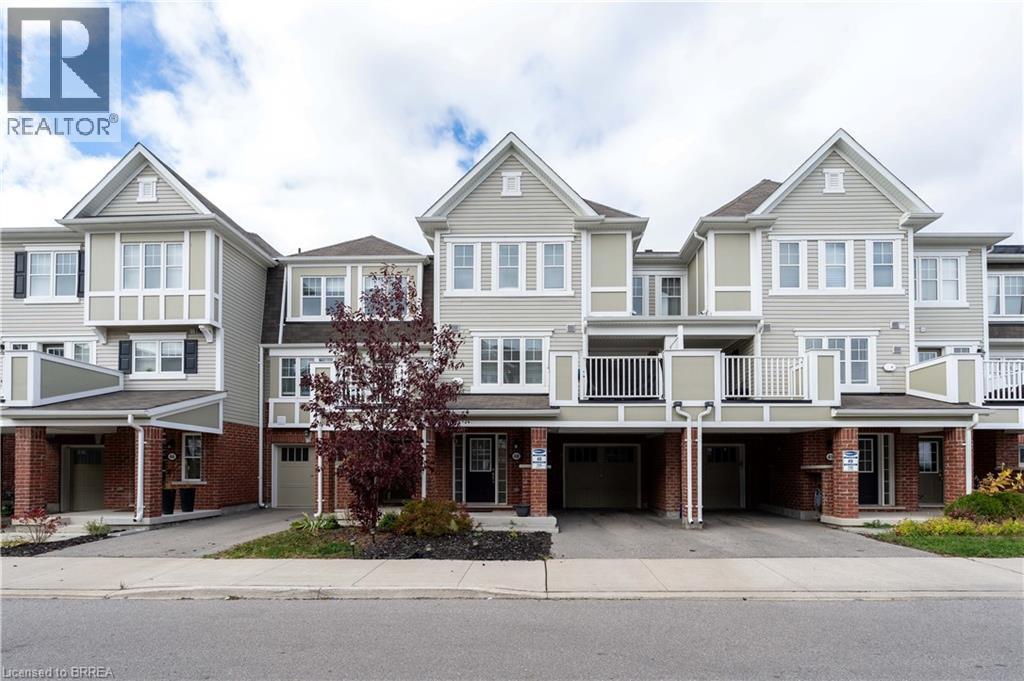 View of front of home with driveway, brick siding, an attached garage, and a residential view - 143 Ridge Road Unit# 48, Cambridge, ON - Outdoor With Balcony With Facade