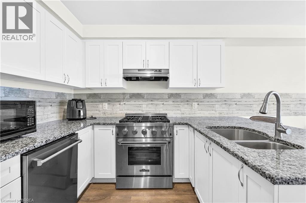 Kitchen featuring white cabinets, stainless steel appliances, and light stone counters - 143 Ridge Road Unit# 48, Cambridge, ON - Indoor Photo Showing Kitchen With Double Sink With Upgraded Kitchen