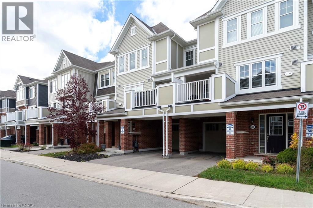 Traditional home with a residential view, brick siding, a carport, asphalt driveway, and a balcony - 143 Ridge Road Unit# 48, Cambridge, ON - Outdoor With Balcony With Facade