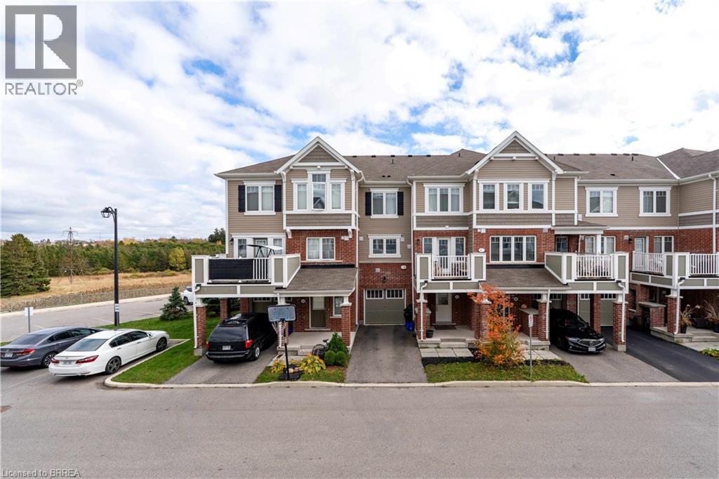 View of front of home with brick siding, driveway, and an attached garage - 143 Ridge Road Unit# 48, Cambridge, ON - Outdoor With Facade