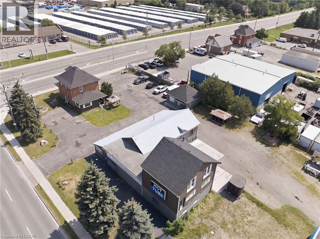 Aerial perspective of multiple structures and paved parking areas - 1360 Rymal Road E, Hamilton, ON
