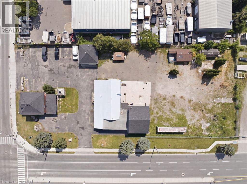 Commercial property featuring multiple structures, paved parking areas, and a substantial undeveloped lot - 1360 Rymal Road E, Hamilton, ON
