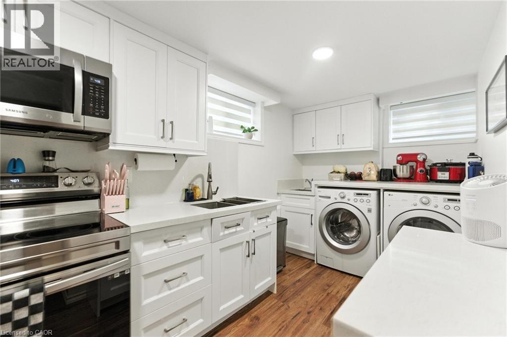 Kitchen-Laundry area with dark wood-type flooring, washer and dryer, and recessed lighting - 90 Toby Crescent Unit# Lower, Hamilton, ON - Indoor Photo Showing Laundry Room