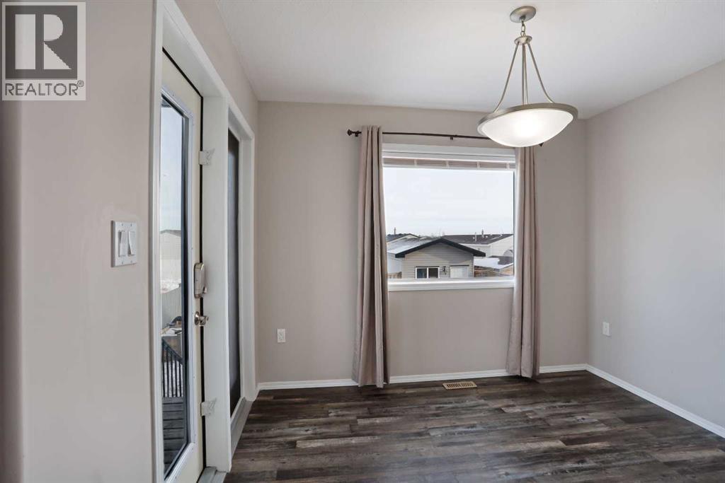 Main Floor - Dinning Room nw/large window & patio doors to covered deck area - 322 17 Street E, Brooks, AB - Indoor Photo Showing Other Room