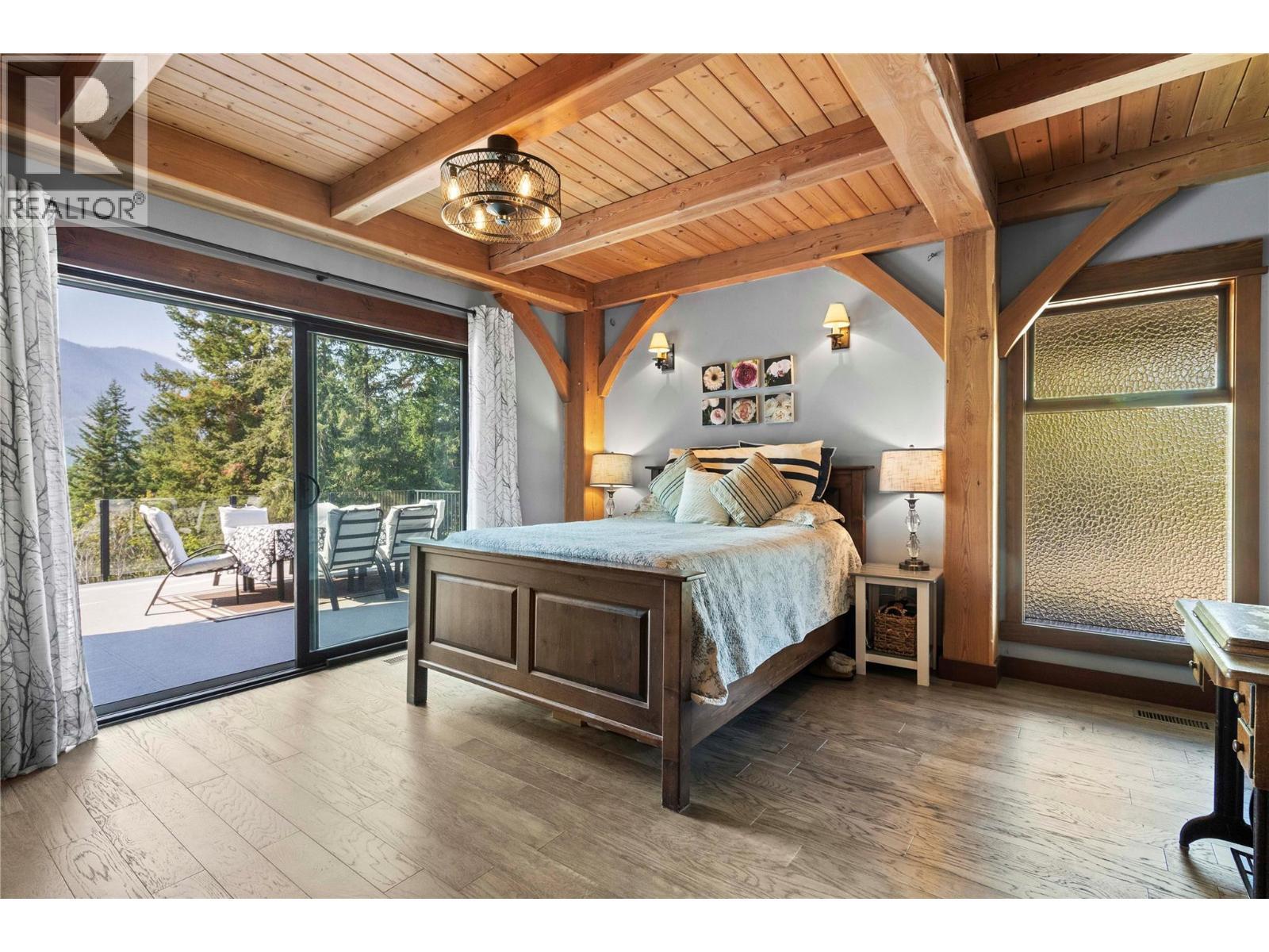 Main floor Primary Bedroom has 8 ft wide sliding doors to deck - 1403 Notch Hill Road, Sorrento, BC - Indoor Photo Showing Bedroom