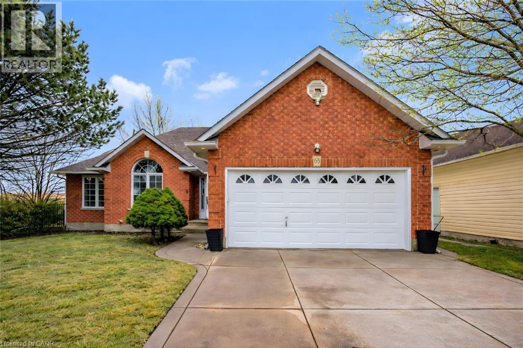 View of front of house featuring brick siding, driveway, a garage, and a front lawn - 65 Thistlemoor Drive, Caledonia, ON - Outdoor