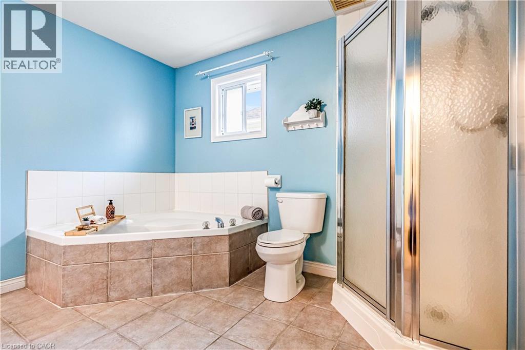 Full bathroom with a shower stall, a bath, and light tile patterned flooring - 65 Thistlemoor Drive, Caledonia, ON - Indoor Photo Showing Bathroom