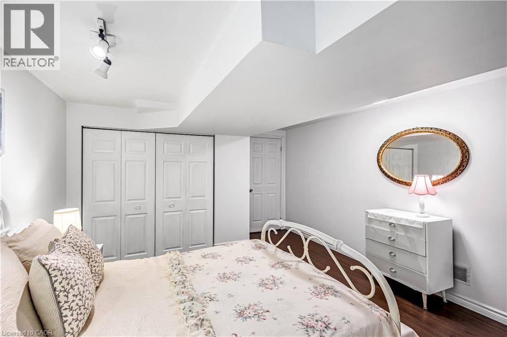 Bedroom with a closet, dark wood-type flooring, and rail lighting - 65 Thistlemoor Drive, Caledonia, ON - Indoor Photo Showing Bedroom