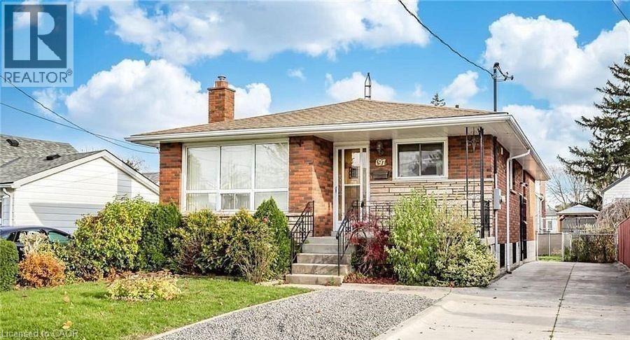 Bungalow-style house with a chimney, stone siding, and a front yard - 197 Craigroyston Road, Hamilton, ON - Outdoor