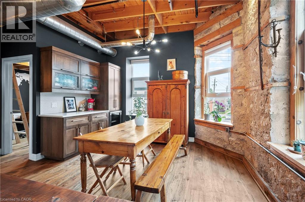 Kitchen featuring a wood ceiling with exposed beams, light countertops, light wood finished floors, wine cooler, and wood finish cabinetry - 25 Concession Street Unit# 201, Cambridge, ON - Indoor Photo Showing Dining Room