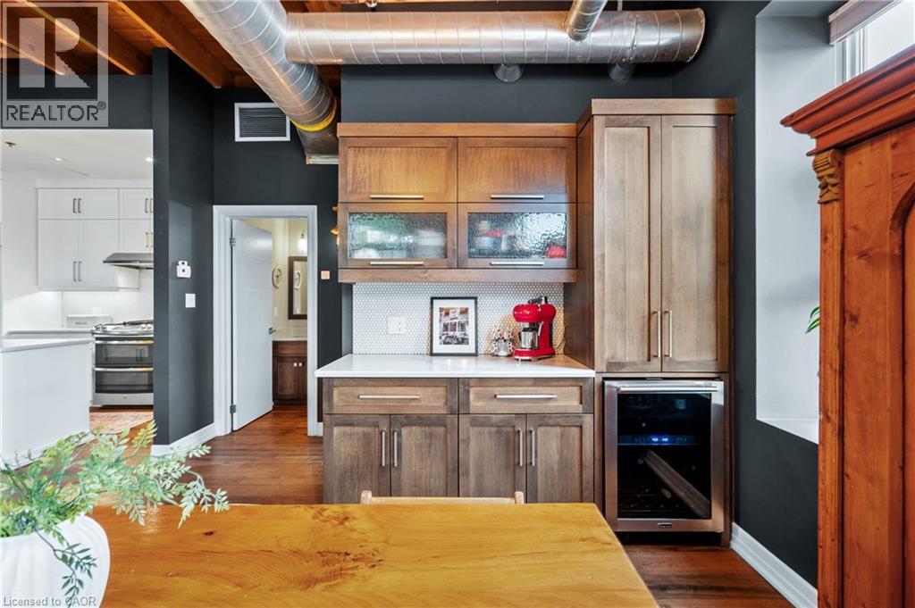 Kitchen with wood finish cabinets, beverage cooler, and dark wood-style flooring - 25 Concession Street Unit# 201, Cambridge, ON - Indoor