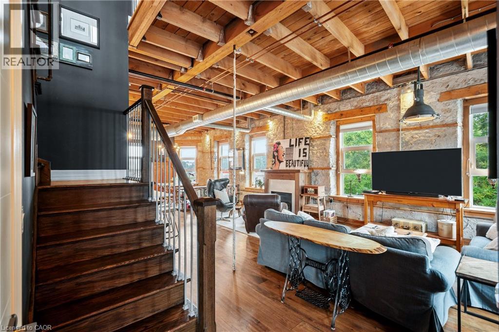 Living room featuring a fireplace, hardwood / wood-style flooring, and wooden ceiling - 25 Concession Street Unit# 201, Cambridge, ON - Indoor Photo Showing Basement