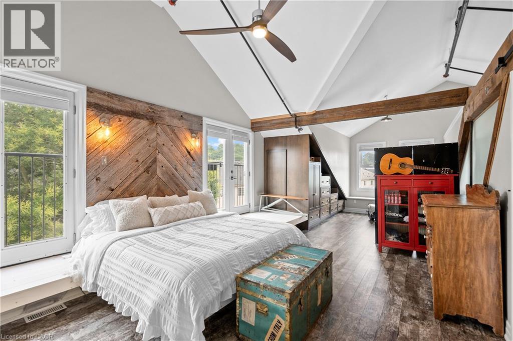 Bedroom featuring dark wood-style flooring, lofted ceiling, ceiling fan, and access to exterior - 25 Concession Street Unit# 201, Cambridge, ON - Indoor Photo Showing Bedroom