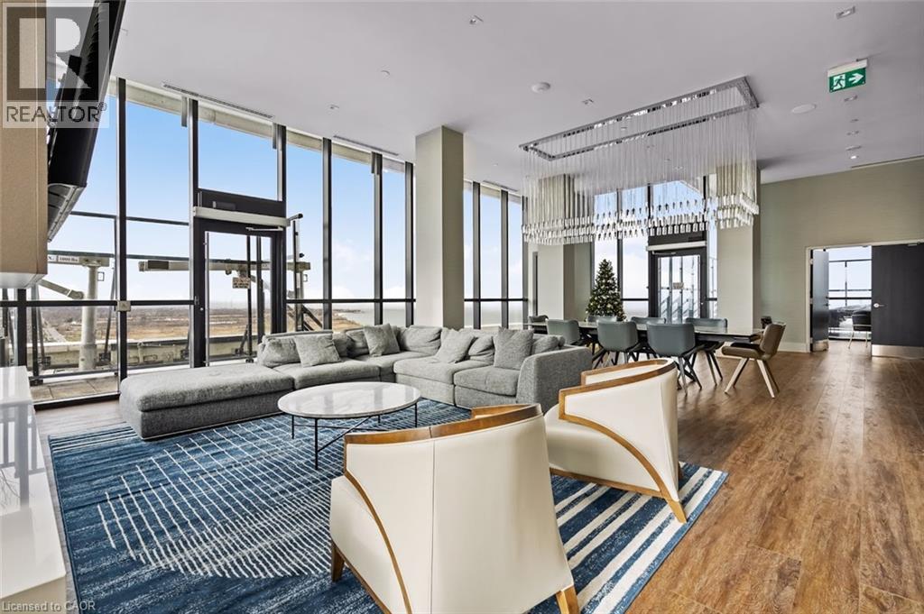 Living area with wood finished floors and a high ceiling - 385 Winston Road Unit# 1311, Grimsby, ON - Indoor