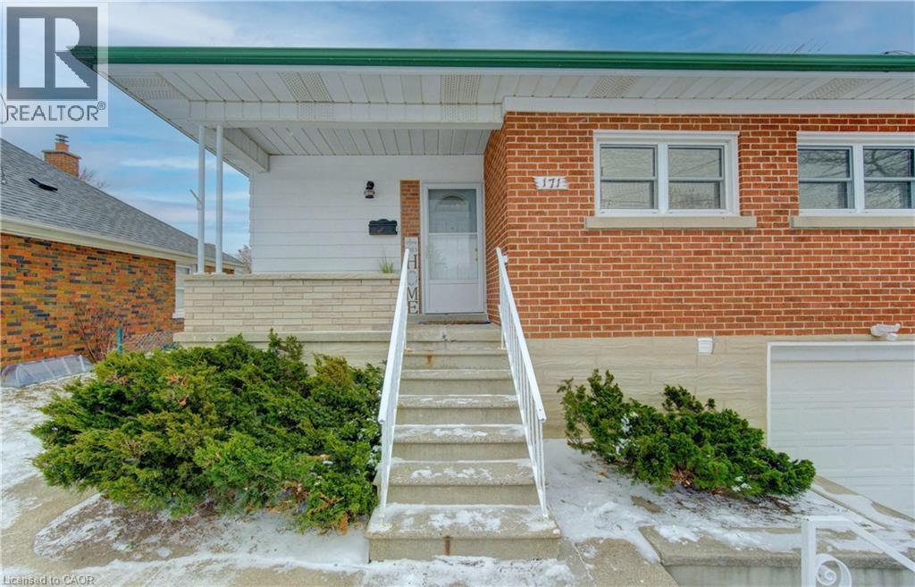 Entrance to property with brick siding, an attached garage, and a porch - 171 Sixth Avenue, Kitchener, ON - Outdoor With Exterior