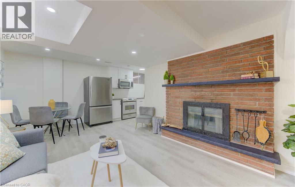 Living area featuring light wood-style floors, a brick fireplace, and recessed lighting - 171 Sixth Avenue, Kitchener, ON - Indoor Photo Showing Living Room With Fireplace