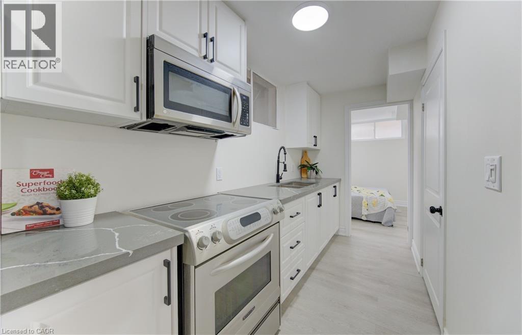 Kitchen featuring electric range oven, stainless steel microwave, and white cabinets - 171 Sixth Avenue, Kitchener, ON - Indoor Photo Showing Kitchen