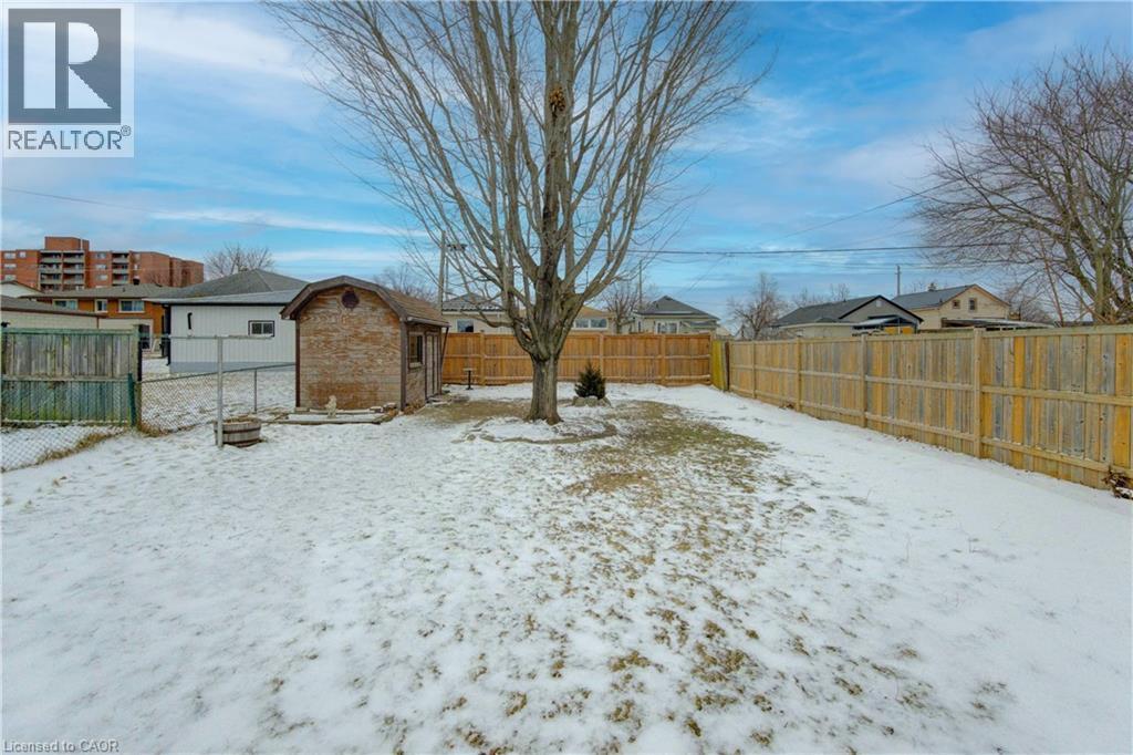 Snowy yard with a fenced backyard and an outbuilding - 171 Sixth Avenue, Kitchener, ON - Outdoor