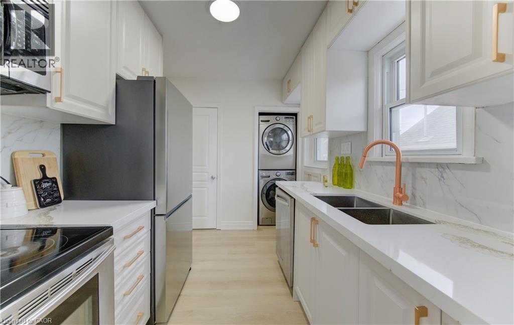 Kitchen with tasteful backsplash, stainless steel appliances, and white cabinetry - 171 Sixth Avenue, Kitchener, ON - Indoor Photo Showing Kitchen With Double Sink