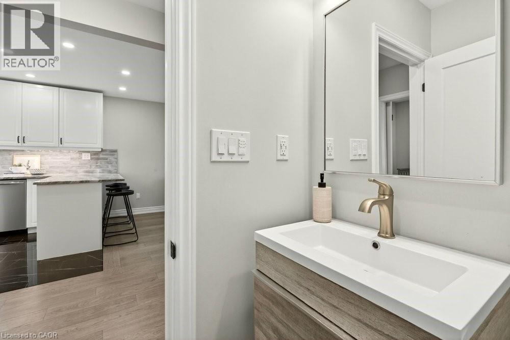 Bathroom featuring vanity, recessed lighting, dark wood-style flooring, and tasteful backsplash - 237 East 32Nd Street, Hamilton, ON - Indoor