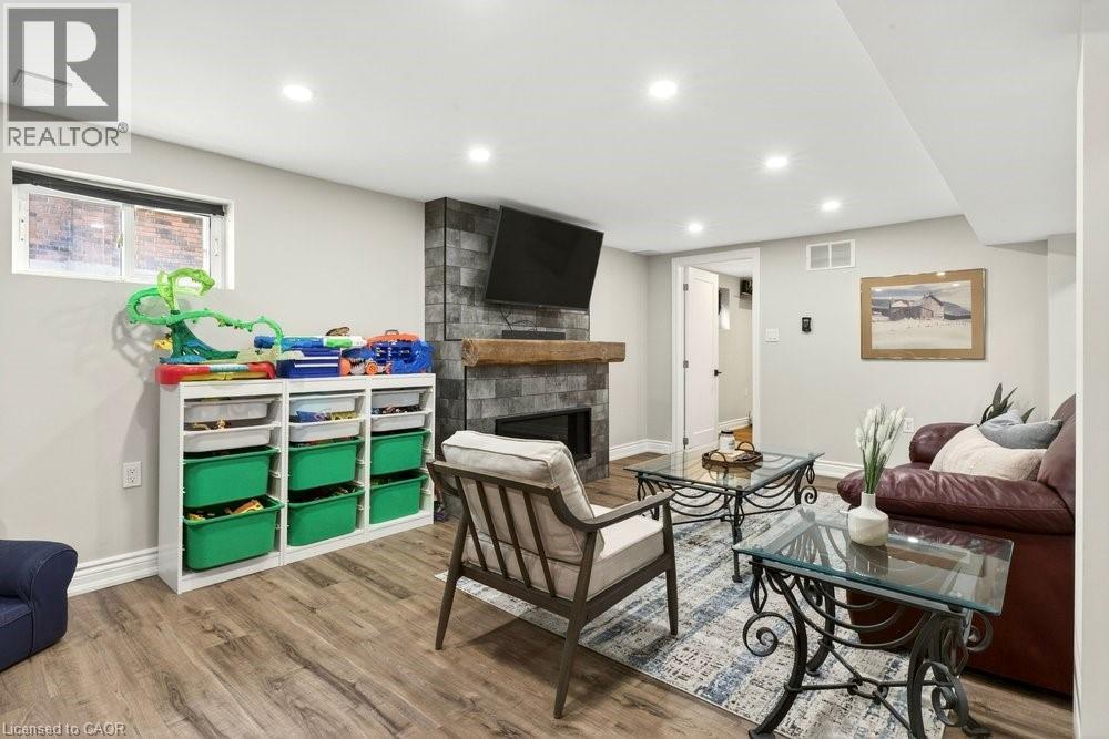 Living room with a fireplace, wood finished floors, and recessed lighting - 237 East 32Nd Street, Hamilton, ON - Indoor With Fireplace