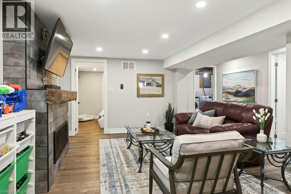 Living area with a tiled fireplace, light wood-style floors, and recessed lighting - 237 East 32Nd Street, Hamilton, ON - Indoor