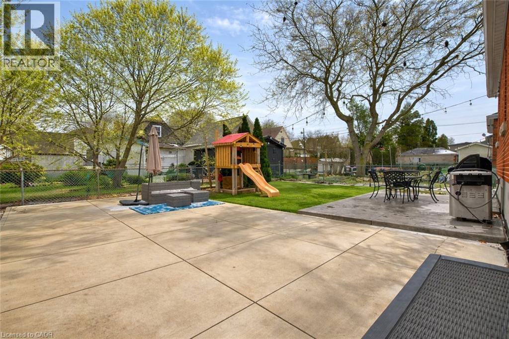 Fenced backyard featuring a patio area, a playground, outdoor dining space, and grilling area - 237 East 32Nd Street, Hamilton, ON - Outdoor