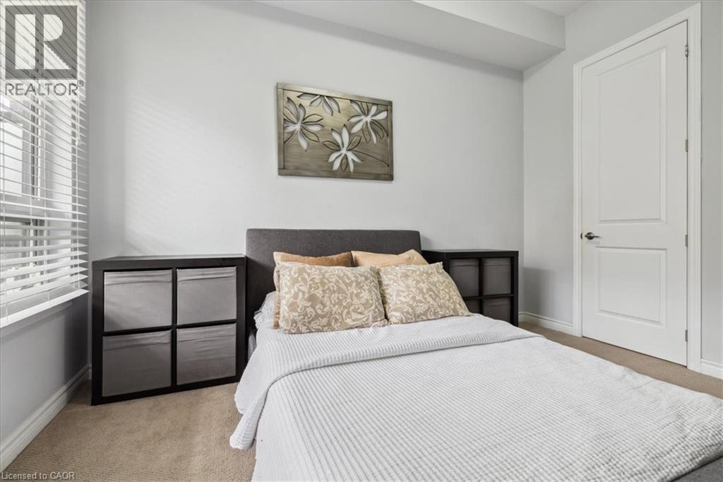 Bedroom with light carpet and baseboards - 40 Esplanade Lane Unit# 102, Grimsby, ON - Indoor Photo Showing Bedroom