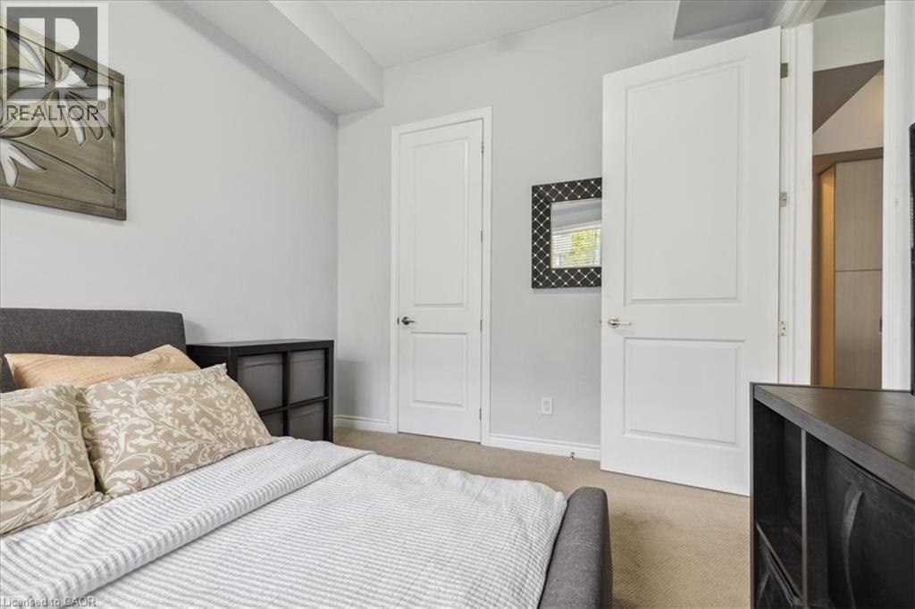 Carpeted bedroom featuring baseboards - 40 Esplanade Lane Unit# 102, Grimsby, ON - Indoor Photo Showing Bedroom