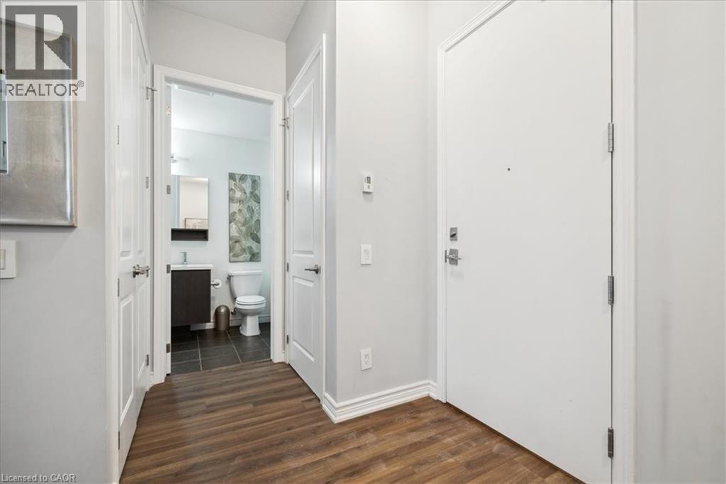 Entryway featuring dark wood finished floors and baseboards - 40 Esplanade Lane Unit# 102, Grimsby, ON - Indoor Photo Showing Other Room