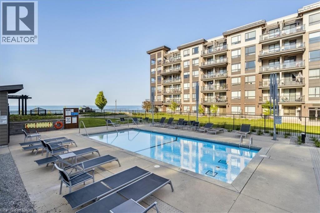 Community pool with a patio area - 40 Esplanade Lane Unit# 102, Grimsby, ON - Outdoor With In Ground Pool