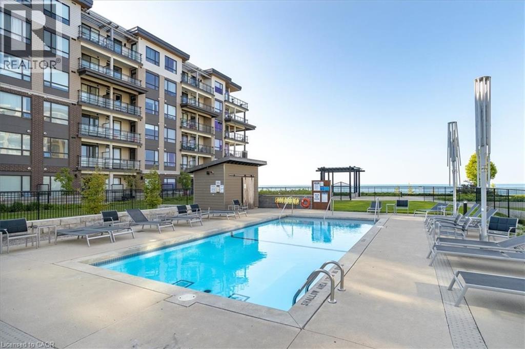 Community pool with a patio area - 40 Esplanade Lane Unit# 102, Grimsby, ON - Outdoor With In Ground Pool