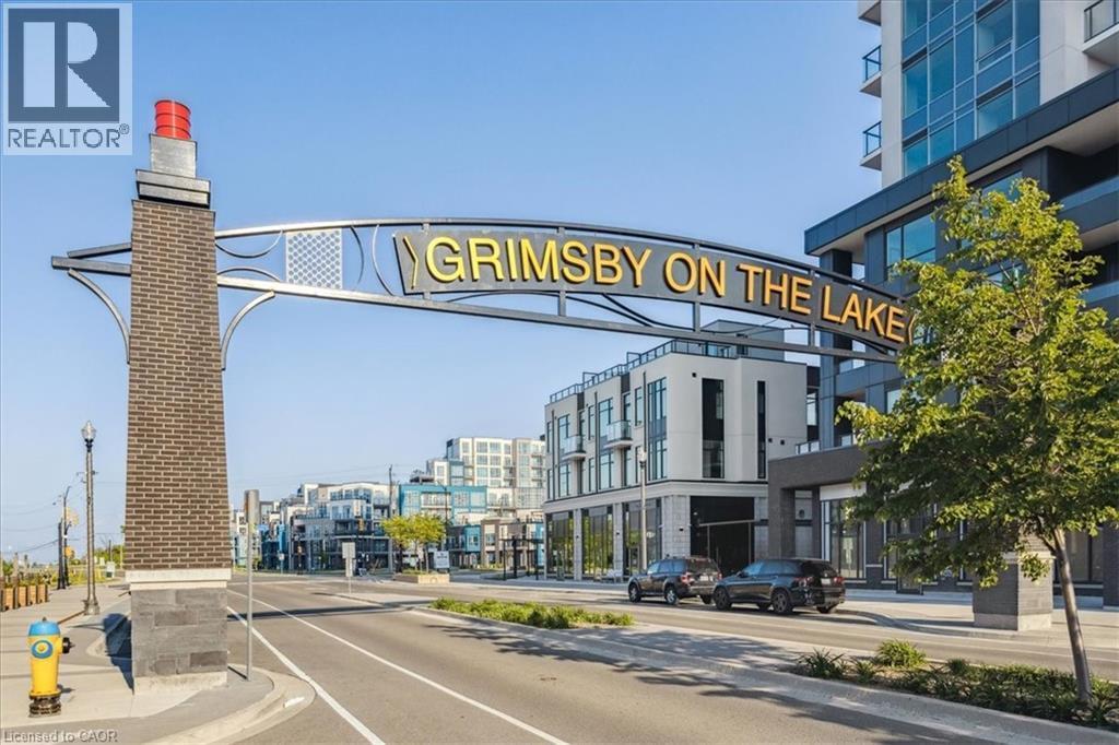 View of asphalt road with sidewalks, curbs, and street lights - 40 Esplanade Lane Unit# 102, Grimsby, ON - Outdoor