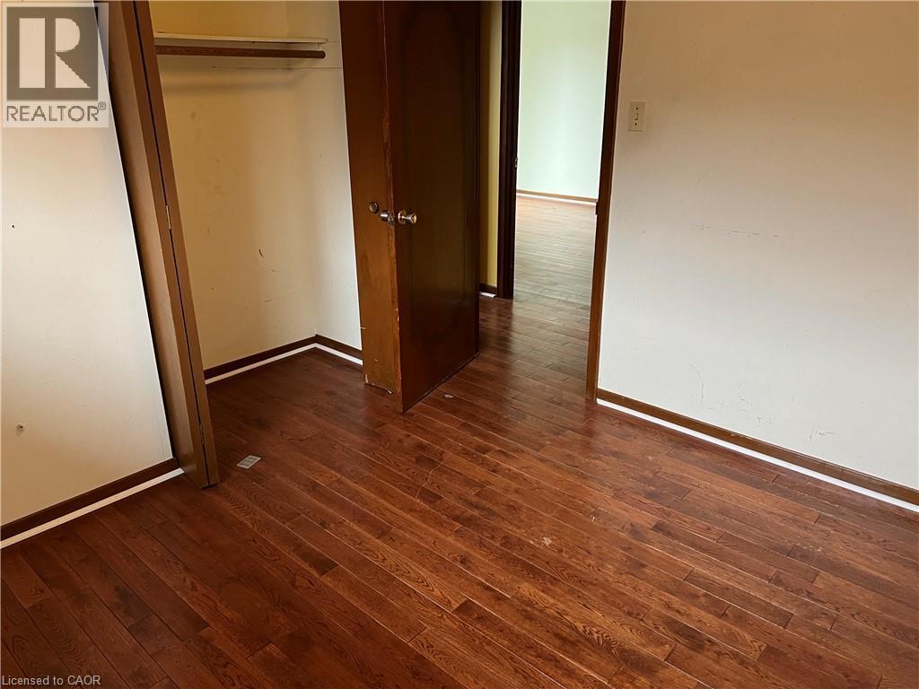 Unfurnished bedroom featuring dark wood finished floors and a closet - 185 Lavina Crescent, Hamilton, ON - Indoor Photo Showing Other Room