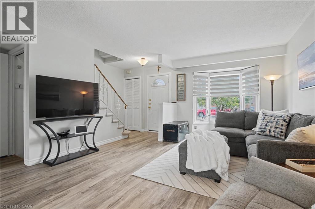Living room with light wood-type flooring and a textured ceiling - 21 Greystone Crescent, St. Catharines, ON - Indoor Photo Showing Living Room