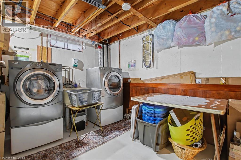 Laundry area featuring finished concrete floors and separate washer and dryer - 21 Greystone Crescent, St. Catharines, ON - Indoor Photo Showing Laundry Room