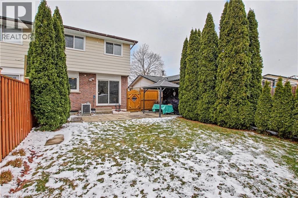 Snow covered back of property with brick siding, a patio area, and a fenced backyard - 21 Greystone Crescent, St. Catharines, ON - Outdoor