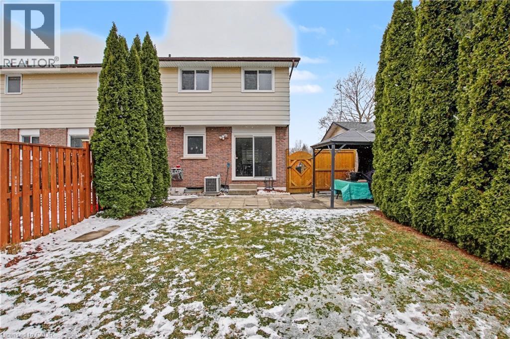 Snow covered property featuring brick siding, a fenced backyard, and a patio - 21 Greystone Crescent, St. Catharines, ON - Outdoor