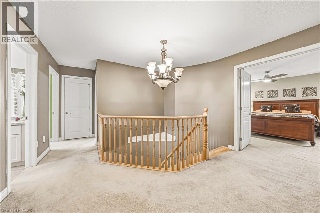 Hall featuring an upstairs landing, carpet flooring, and suspended lighting - 120 Valiant Circle, Hamilton, ON - Indoor Photo Showing Other Room