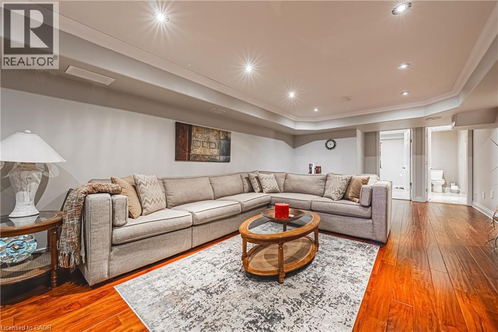Living room featuring wood-type flooring, a raised ceiling, crown molding, and recessed lighting - 120 Valiant Circle, Hamilton, ON - Indoor Photo Showing Living Room