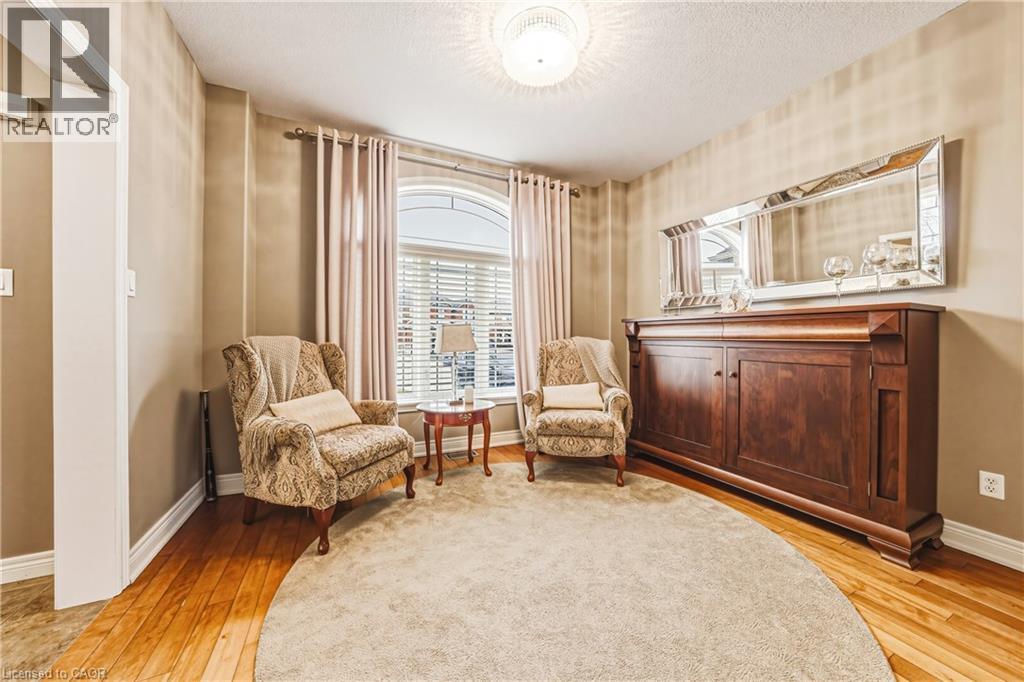 Living area with light wood-style flooring and a textured ceiling - 120 Valiant Circle, Hamilton, ON - Indoor