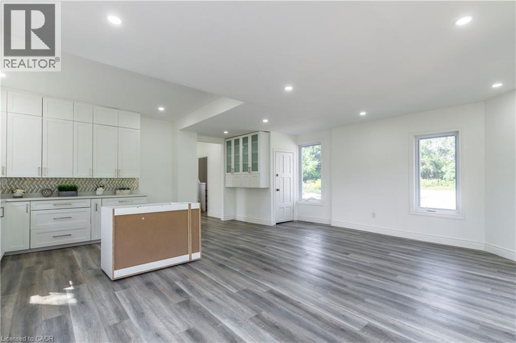 Kitchen with open floor plan, light countertops, backsplash, a kitchen island, and dark wood-type flooring - 1411 E 56 Highway, Glanbrook, ON - Indoor Photo Showing Kitchen