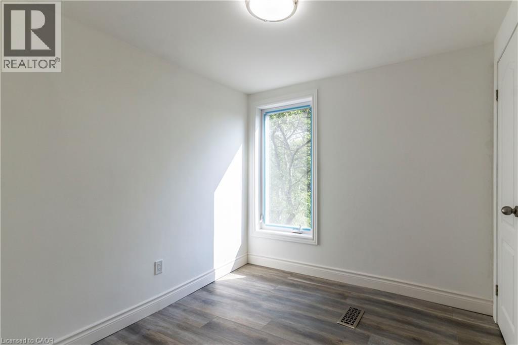 Unfurnished room with dark wood-type flooring and baseboards - 1411 E 56 Highway, Glanbrook, ON - Indoor Photo Showing Other Room