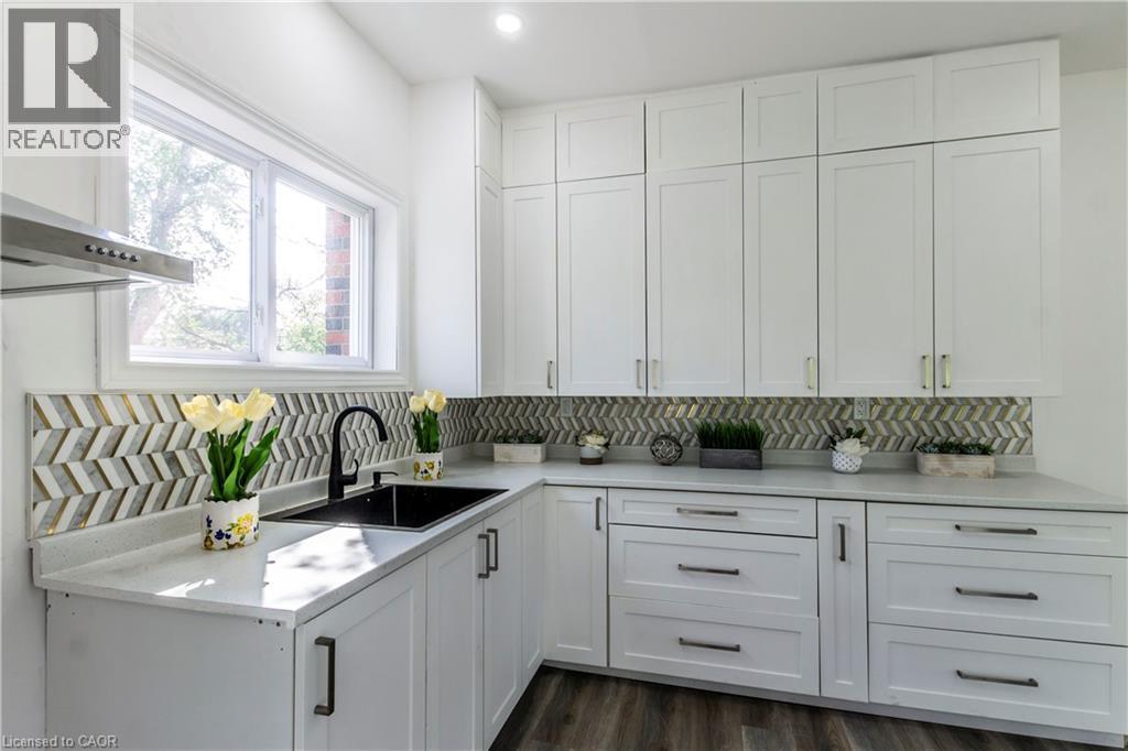 Kitchen featuring white cabinetry, ventilation hood, dark wood-style flooring, tasteful backsplash, and recessed lighting - 1411 E 56 Highway, Glanbrook, ON - Indoor Photo Showing Kitchen