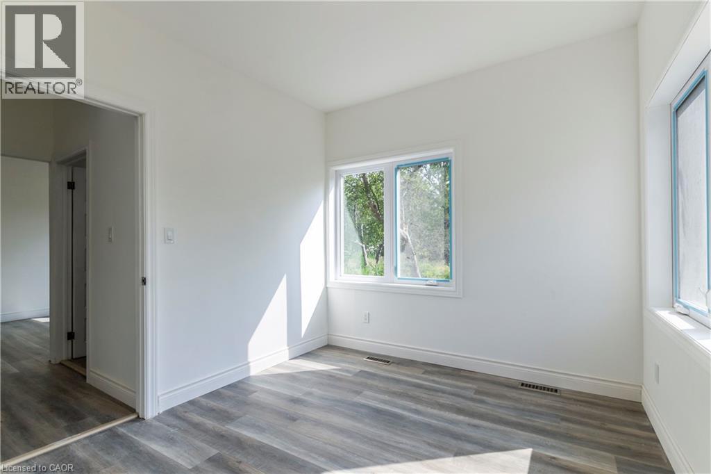 Unfurnished room with wood finished floors and baseboards - 1411 E 56 Highway, Glanbrook, ON - Indoor Photo Showing Other Room
